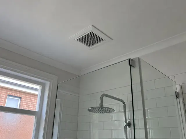 Bathroom ceiling exhaust fan above a glass shower in a tiled bathroom in Balmain