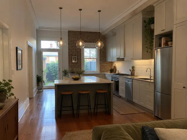 Three glass pendant lights above a kitchen island in a modern kitchen with brick feature wall in Balmain